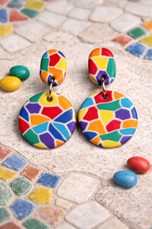 Colorful geometric-patterned earrings on a mosaic tile background